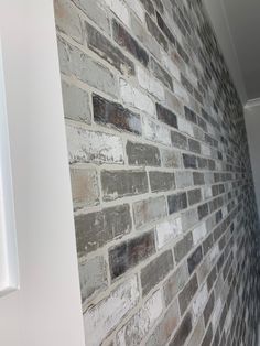 a brick wall with white trim and grey bricks on the bottom half is shown in this image