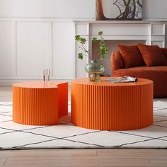 two orange tables sitting on top of a white rug