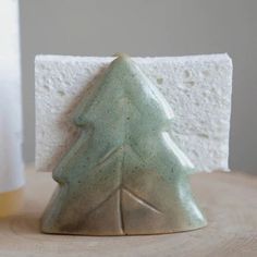 a small ceramic christmas tree sitting on top of a wooden table