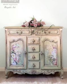 an old dresser with flowers painted on the doors and drawers is sitting in front of a white wall