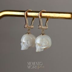 💀CUSTOM made to order Every single piece is hand-carved for the order. Please notice that every skull piece is unique and may have a slightly different shape  💀PEARLS:  Genuine White Freshwater Pearls  Ranging in size, from 11mm to 12mm.  💀Earrings: 14K Yellow Gold Diamond-Set Lever-Backs 💀 Authentic Metal Quality Guaranteed! Rest assured that all the metal qualities mentioned in the description are accurately represented. Occasionally, due to the small size of the product, a hallmark may not be stamped onto the item. You can verify the authenticity of the metal at any local jewelry store. We prioritize transparency to ensure you receive the quality you expect. 💀 𝕿𝖍𝖆𝖓𝖐 𝖞𝖔𝖚 𝖋𝖔𝖗 𝖘𝖍𝖔𝖕𝖕𝖎𝖓𝖌 𝖜𝖎𝖙𝖍 𝕸𝖊𝖒𝖊𝖓𝖙𝖔 𝕸𝖔𝖗𝖎 𝕻𝖊𝖆𝖗𝖑𝖘! Elegant Handmade Bone-colored Jewelry, Yellow Gold Skull Jewelry For Gift, Elegant Skull-shaped Jewelry For Gifts, Elegant Skull Shaped Jewelry For Gifts, Luxury Skull Shaped Jewelry For Gift, Luxury Skull Jewelry For Gifts, Luxury Engraved Skull Jewelry, Pearl Skull, Carved Pearl