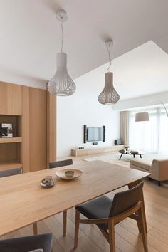 a dining room table with two chairs and a television on the wall in the background