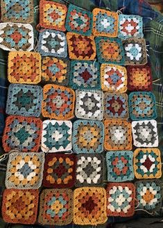 a crocheted blanket with many squares on it, all in different colors and shapes