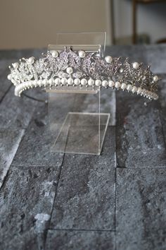 Tiara / Headpiece Display Stand Put your beautiful wedding tiara or bridal headpiece on display on a shelf. 2 levels for display. Tiara shown for use example only and sold separately. Comes in our signature beribboned keepsake box. Ships out within 3-5 Business Days, via the shipping method chosen at checkout. Crown Jewelry Display, Tiara Headpieces, Floral Veil, Silver Tiara, Silver Head Piece, Gold Tiara, Gold Headpiece, Headpiece Jewelry, Gold Belts