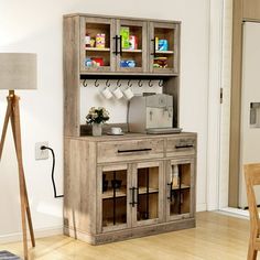 a wooden cabinet sitting in the middle of a living room next to a table and chair