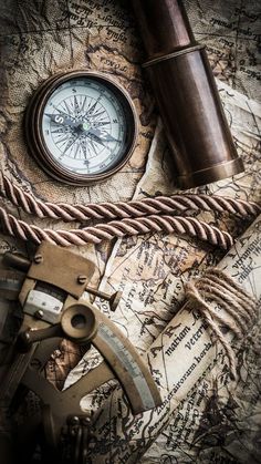 an old compass, telescope and rope on a map