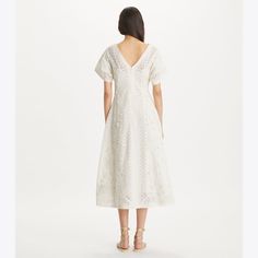 The v-neck dress has a vintage-inspired silhouette, expertly constructed in embroidered linen and cotton. Flattering and versatile, with a nipped-in waist, flutter sleaves and a tea-length skirt. Spring V-neck Chikankari Embroidered Dress, Elegant V-neck Dress With Chikankari Embroidery, Chic Embroidered Linen Dress, Chic Linen Dresses With Embroidery, Embroidered V-neck Midi Dress For Garden Party, Elegant Embroidered Dress With Broderie Anglaise For Spring, Elegant Cotton Embroidered Dress For Spring, Summer Linen Dress With Broderie Anglaise, Elegant Linen Dresses With Broderie Anglaise