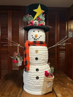 a snowman made out of rope with a top hat and scarf