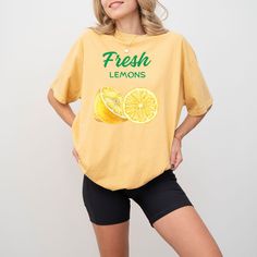 🍋 Fresh Lemons: Sweet & Sunny Style 🍋  Pucker up for summer with our "Fresh Lemons" tee, a burst of sunshine for your wardrobe. Made from soft, breathable cotton, this vibrant design showcases juicy lemon graphics and the words "Fresh Lemons" in a playful font. Product Details: 100% cotton Relaxed, comfortable fit Eye-catching lemon graphics and "Fresh Lemons" text Available in multiple sizes and colors Casual Cotton T-shirt With Lemon Print, Lemon Print Summer Tops, Summer Lemon Print Tops For Vacation, Summer Tops With Lemon Print For Vacation, Yellow T-shirt With Lemon Print For Spring, Spring Fruit Print Crew Neck Tops, Summer Cotton Tops With Slogan, Yellow Summer Slogan Top, Yellow Summer Shirt With Funny Print