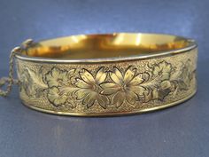 Antique bangle bracelet with a black traced floral design.  Box clasp works but gets a little stuck sometimes.  Marked gold filled on the tongue of the box clasp.  Some age related wear and patina, small surface dings etc.  Visit Ribbons Edge for more great pieces of vintage and antique jewelry!  All items added to your cart at Ribbons Edge will automatically combine shipping. To stay up to date with my newest offerings, follow me on IG @ RibbonsEdge Victorian Gold Cuff Bracelet Gift, Ornate Hinged Bracelets For Gifts, Victorian Style Yellow Gold Bangle Gift, Heirloom Hinged Bangle As Gift, Heirloom Hinged Bangle Gift, Antique Hinged Cuff Bracelet Gift, Antique Hinged Bangle For Gift, Antique Hinged Bangle As Gift, Antique Gold Bangle For Gift