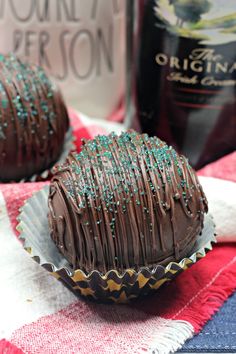 two chocolate covered desserts sitting on top of a red and white checkered table cloth