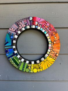 a colorful stained glass wreath hanging on the side of a building