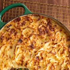 a casserole dish with green beans and cheese in a pan on a cooling rack