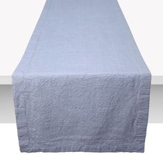 an image of a bed with a blue linen cover on the headboard and foot board