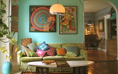 a living room filled with furniture and paintings on the wall