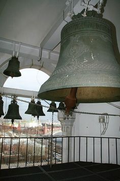 several bells hanging from the ceiling in a room