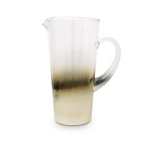 a pitcher filled with liquid sitting on top of a white table