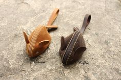 two leather purses sitting on top of a rock