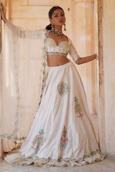 Ivory chanderi silk lehenga with ruffled border, Mughal inspired vintage pattern, multi color thread, sequin and bead embroidery. Paired with sweetheart neck blouse with all over butti pattern embroidery and dupatta with scalloped cut work border.
Components: 3
Pattern: Embroidered and Embellished
Type Of Work: Thread, Sequin and Bead Work
Neckline: Sweetheart Neck
Sleeve Type: Three Quarter Sleeves
Fabric: Chanderi Silk, Zari, Lining: Cotton Silk
Color: Ivory
Other Details: 
Scalloped cut work White Art Silk Lehenga With Intricate Embroidery, Off White Raw Silk Designer Sets, Off White Raw Silk Designer Wear Sets, Off White Raw Silk Sets For Designer Wear, Traditional Drape Raw Silk Cream Choli, Traditional Cream Raw Silk Choli, Traditional Drape Cream Raw Silk Choli, Off White Raw Silk Set For Festivals, Off White Bollywood Raw Silk Set