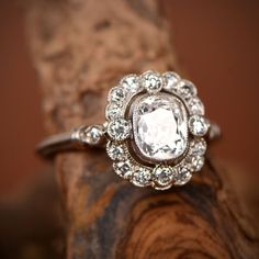 a diamond ring sitting on top of a piece of wood