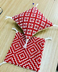 a red and white bag sitting on top of a wooden table next to a pair of scissors