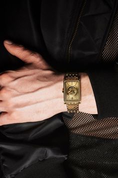 Man wearing VIEREN Gold Waves Men's Watch with modern black outfit Rectangular Skeleton Dial Watch As A Gift, Rectangular Skeleton Dial Watch For Gift, Gold Rectangular Watches With Subdials, Formal Rectangular Watch With Skeleton Dial, Elegant Rectangular Watch With Analog Display, Elegant Rectangular Analog Watch Accessories, Formal Rectangular Skeleton Dial Watch, Elegant Rectangular Automatic Watch, Luxury Yellow Gold Watch Accessories With Analog Display