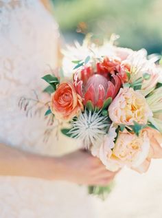 a bride holding a bouquet of flowers in her hands