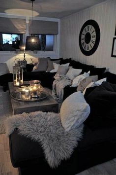 a living room filled with black couches and pillows