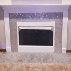 a white fireplace with silver glitter on the mantle