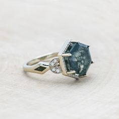 an engagement ring with a large blue stone surrounded by diamonds