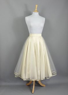 This show stopping skirt is made from a layer of Champagne coloured silk dupion with two layers of tulle hemmed in Gold trim. The tulle layers are a double circle which means lots and lots of volume! Wear with a 'Swing' petticoat for extra swish on the dance floor! Seen in the last photo without a petticoat underneath. The skirt is designed to be worn quite high on the waist and has a snug fitting waistband so please check your own measurement against our standard sizes before ordering. This skirt can be made in a range of standard sizes or can be made to fit your exact waist measurement if you are inbetween sizes for no extra cost. Size UK 6 is made to fit Waist 24/5"  Size UK 8 is made to fit Waist 26/27"  Size UK 10 is made to fit Waist 27/28"  Size UK 12 is made to fit Waist 29/30"  Si Organza Full Skirt Dress With Tulle Detail, Party Full Crinoline Skirt, Fitted Full Tulle Petticoat, Fitted Organza Tiered Skirt, Fitted Full Tulle Skirt Petticoat, Elegant Organza Petticoat With Tulle Skirt, Elegant Spring Tulle Petticoat, Fitted Long Organza Skirt, Fitted Tulle Dress With Lined Skirt