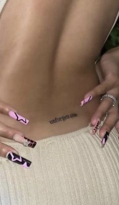 a woman with pink and black nail polish on her stomach, showing the lower part of her body