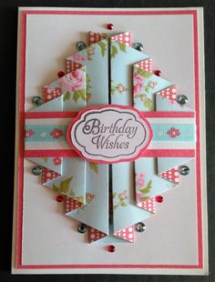 a birthday card with an origami design on the front, and pink ribbon around the edges