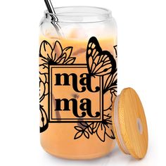 a glass jar filled with liquid next to a wooden lid that says madma on it