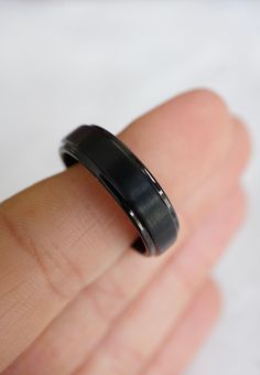 a man's hand with a black ring on it