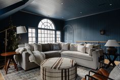 a living room filled with furniture and a large window in the wall next to it