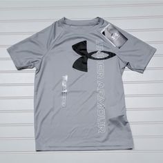 the under armour t - shirt is laying on top of a white garage door and it's attached to a clipboard