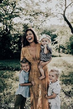 a woman with three children standing in the grass