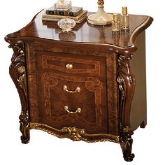 an ornate wooden cabinet with drawers and gold trimmings on the top, in front of a white background