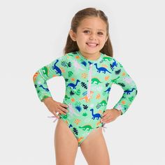 Keep your toddler's skin shielded from the sun's rays while they enjoy at the beach or pool with the Long-Sleeve One-Piece Swimsuit from Cat & Jack™. This long-sleeve swimsuit features a printed pattern to spruce up the look. The rashguard swimsuit is made with soft and stretchy fabric with full lining to offer the right comfort and flexibility for swimming, playing in the sand and more. It comes with front half-length zipper for easy dressing, and the snap tab helps protect their chin from scra Playful Stretch Swimwear With Uv Protection, Playful Blue Rash Guard For Pool, Long Sleeve Swimwear With Upf 50+ For Play, Playful Long Sleeve Onesie For Summer, Playful Summer Rash Guard With Upf 50+, Blue Rash Guard For Beach Season Playwear, Playful Long Sleeve Summer Onesie, Green Bodysuit For Surfing In Beach Season, Green Bodysuit For Surfing During Beach Season