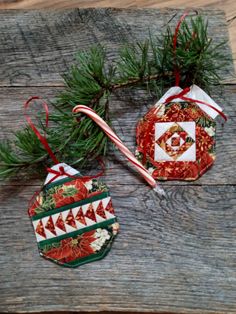 two christmas ornaments are sitting on a wooden table