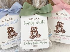 three baby shower gift bags with ribbons and tags on the front one has a teddy bear