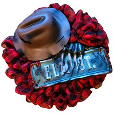 a cowboy hat is on top of a red mesh wreath with the word florist