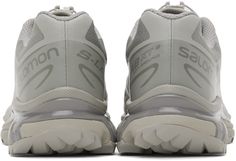 the back view of a pair of running shoes with white and grey uppersoles