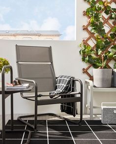 a chair sitting on top of a tiled floor next to a potted plant and window