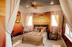 a bed room with a neatly made bed next to two windows and a ceiling fan