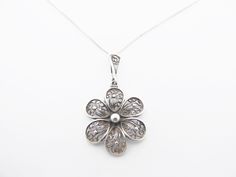 Delightful tiny silver filigree flower pendant stamped 935 which indicates it is argentium, a slightly higher grade of silver than sterling.  European, probably German or Austrian. It has an ornamental bale and is paired with a very fine silver chain.  In very good condition, it is very old and has quite a lot of normal tarnish and could benefit from a careful clean if wanted 2.4 cm (just under 1 inch) across the flower Drop with bale 4 cm (1 ½ inches) Chain 46 cm (18 inches) long To return to my shop's home page: https://www.etsy.com/uk/shop/jewelbirdvintage For more pendants: https://www.etsy.com/uk/shop/jewelbirdvintage?section_id=14637857 Sculptural Necklace, Antique Filigree, Art Nouveau Floral, Silver Necklaces Women, Filigree Jewelry, Enamel Brooch, Silver Filigree, Flower Pendant, Vintage Jewellery