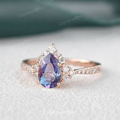 an engagement ring with a large blue stone surrounded by small white and rose gold diamonds