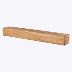 a wooden shelf sitting on top of a white wall