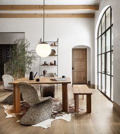 a room with a table, chairs and a clock on the wall next to it